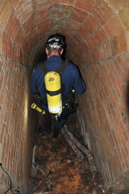 A Catalan police officer makes the first descent into the shelter.