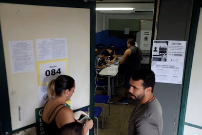 Eleitores esperam para exercer seu direito ao voto em um colégio eleitoral do Rio de Janeiro.