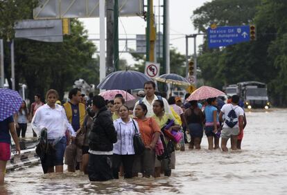 La gente camina por las calles inundadas en Acapulco.