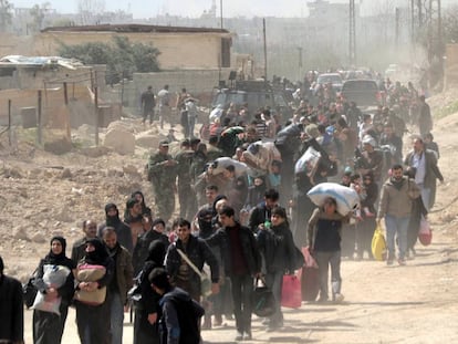 Cientos de civiles abandonan la zona de Guta Oriental, en la zona rural de Damasco (Siria) este jueves.