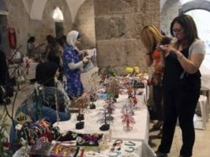 Mujeres sirias exponen objetos de artesanía durante una exposición en al-Takiyyeh as-Sulaymaniyyeh, que forma parte de las ruinas de un edificio otomano que fue levantado en 1553, en Damasco (Siria). Con la muestra se quiere impulsar el turismo en el país y recuperar la actividad presente en la ciudad antes de estallar el conflicto civil en marzo de 2011. EFE/Archivo