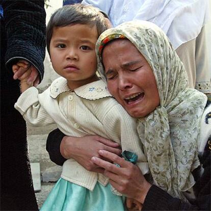 La esposa de un hombre muerto en la revuelta uzbeka se abraza a su hija durante los funerales celebrados en Andiyán.