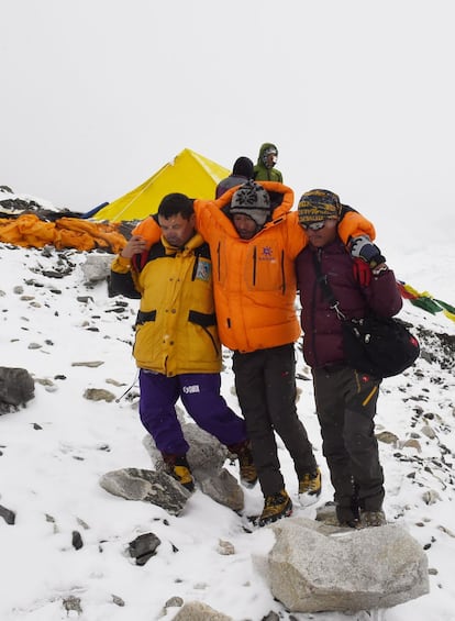 Dos membres de l'equip de rescat socorren un ferit al camp base.