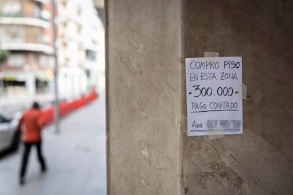 Un cartel colgado en un portal anuncia la compra de un piso con pago al contado en Barcelona.