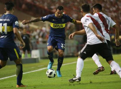 Carlos Tevez intenta escapar de la marca de los defensas de River en Mar del Plata.