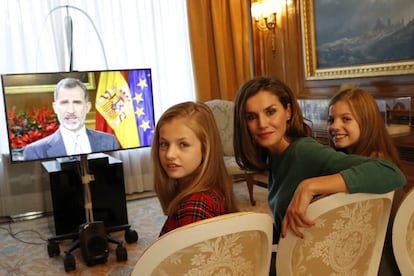 Desde la izquierda, la princesa Leonor, la reina Letizia y la infanta Sofía miran a través de una pantalla el mensaje de Navidad del Rey durante su grabación en el palacio de la Zarzuela.