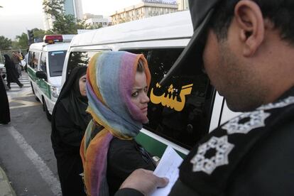 Un agente toma el nombre de una mujer detenida en Teherán.