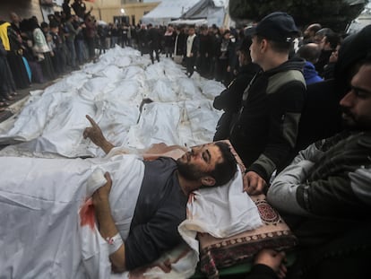 Un herido durante el bombardeo del campo de Maghazi, junto a los cadáveres de víctimas del ataque israelí, este lunes.