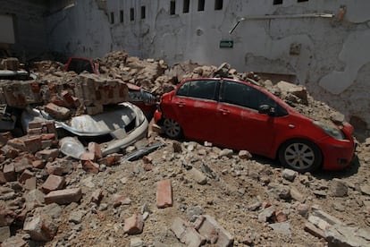 Diversos cotxes han quedat soterrats entre les restes d'un edifici malmès pel terratrèmol.