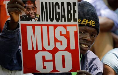 Un manifestante sujeta una pancarta que dice "Mugabe debe irse" durante las protestas ante el Parlamento de Zimbabue el 21 de noviembre.
