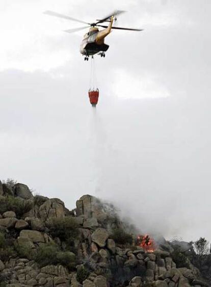 Un helicóptero interviene en la extinción del fuego en El Berrueco.