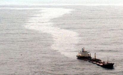 El <i>Prestige,</i> ya muy escorado y soltando una gran mancha de fuel, frente a la costa gallega el 14 de noviembre de 2002.