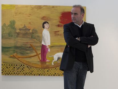 El pintor Juan Vida, junto a una de las obras que expone en Granada.