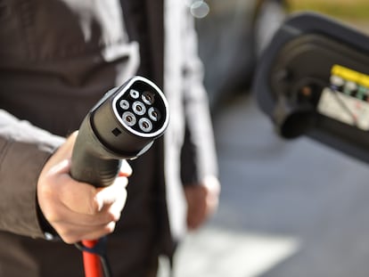 Un conductor recarga su coche eléctrico.