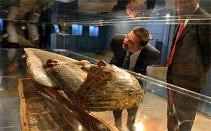 Dos visitantes observan uno de los sarcófagfos expuestos en la muestra sobre los faraones en Alicante