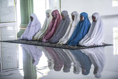 Un grupo de estudiantes indonesas participa en una oración en el interior de la mezquita de la escuela Al Hidayah en Sei Mencirim (Indonesia).