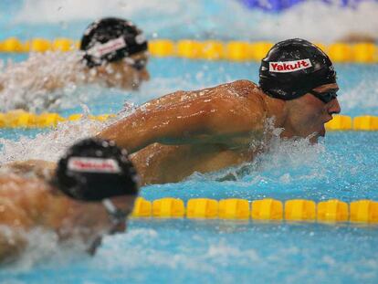 Ryan Lochte, destacado entre dos rivales.