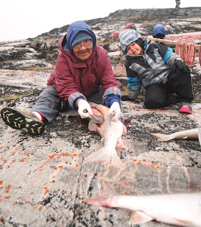 Annie Atighioyak y su sobrina nieta, Sarah Evalik, preparan un pescado en el río Perry