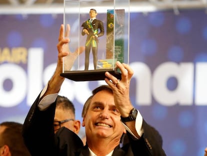 Jair Bolsonaro segura um boneco que o representa em Curitiba no dia 29 de março.