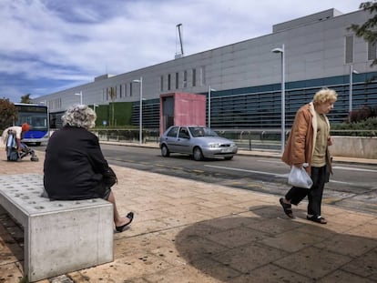 Usuarios del transporte p&uacute;blico esperan la llegada del autob&uacute;s en el hospital universitario Son Espases, en Palma.
