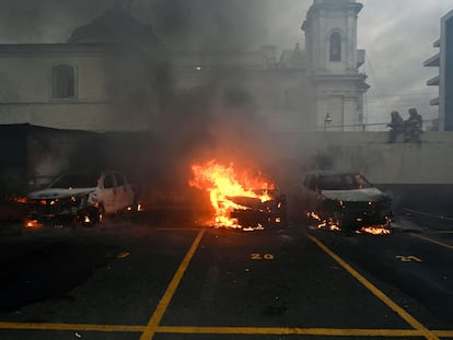 Algunos de los autos quemados en el estacionamiento del Congreso guatemalteco, este martes.