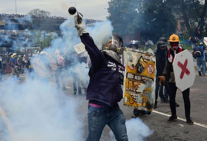 Un manifestante opositor a Maduro lanza un objeto a la policía durante las protestas en Caracas (Venezuela).