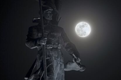 La luna llena brilla tras una estatua dedicada al Ejército Rojo en Vladivostok (Rusia).