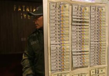 Un policía boliviano muestra parte de los 7.240 dólares recuperados en una vivienda, luego de que el Banco Central de Bolivia (BCB) sufriera dos robos por 210.000 dólares, de los que son sospechosos tres empleados y dos personas ajenas a la entidad.