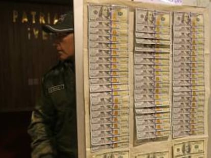 Un policía boliviano muestra parte de los 7.240 dólares recuperados en una vivienda, luego de que el Banco Central de Bolivia (BCB) sufriera dos robos por 210.000 dólares, de los que son sospechosos tres empleados y dos personas ajenas a la entidad.