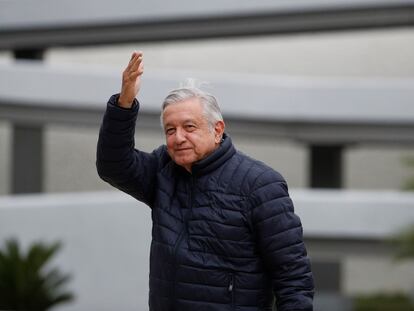 El presidente Andrés Manuel López Obrador saluda a sus seguidores, que aplauden desde un muro exterior, después de visitar las instalaciones en un hospital del IMSS.