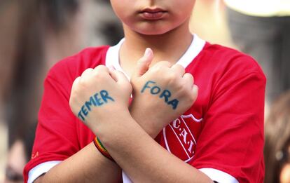Un joven manifestante enseña sus manos pintadas con el eslogan 'Temer Fora' durante una manifestación en São Paulo (Brasil).