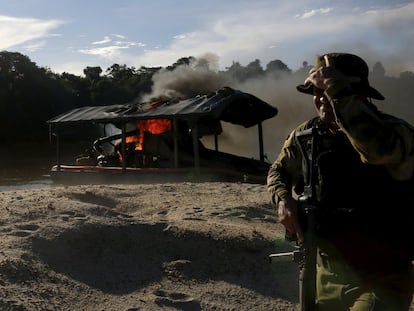 Agente do Ibama em um garimpo ilegal queimado nas margens do rio Uraricoera, em Roraima.