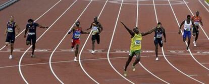 Usain Bolt levanta los brazos tras entrar en la meta por delante. Tras él, de izquierda a derecha, Spearmon, Dix, Martina, Dzingai, Crawford, Malcolm y Collins.