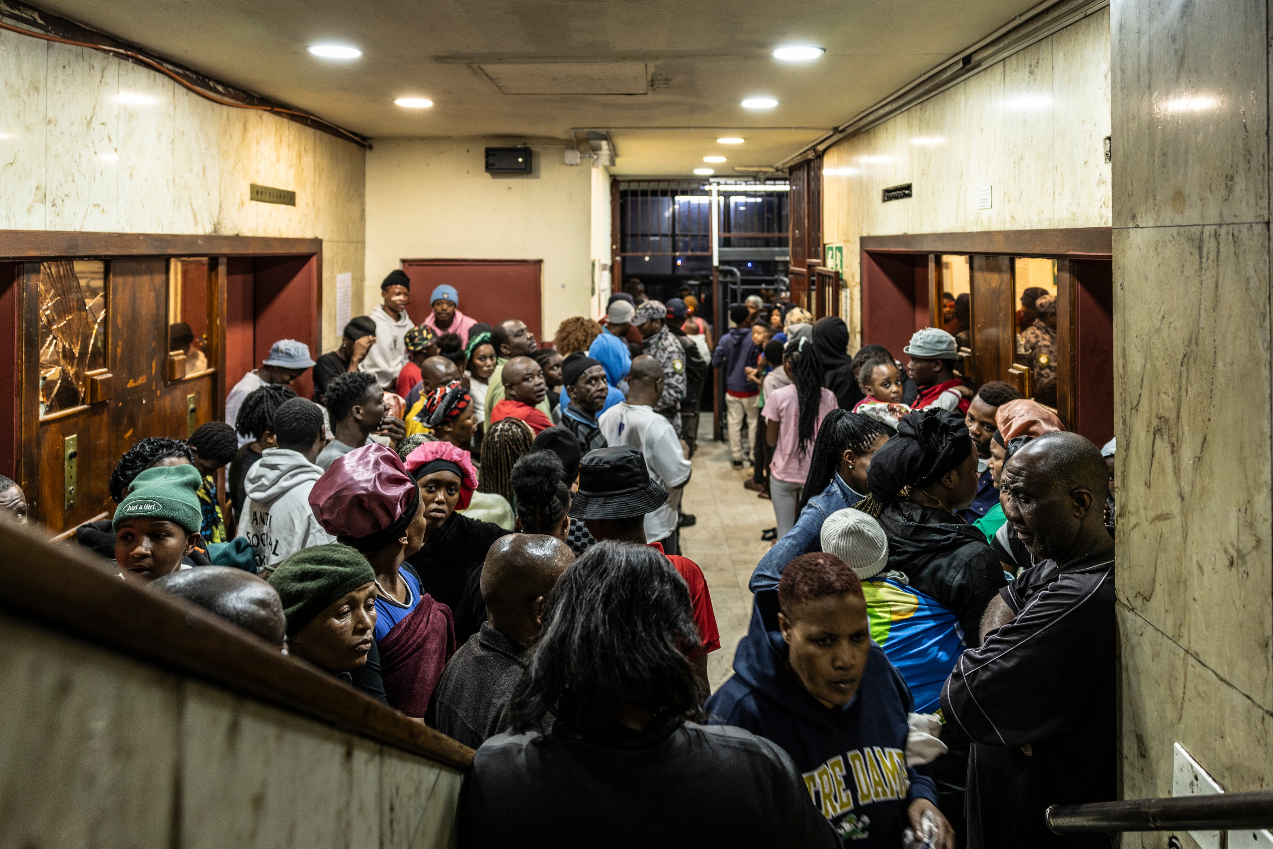 Los residentes de un edificio secuestrado en el centro de Johannesburgo esperan que se revisen sus documentos, el 18 de diciembre de 2025.