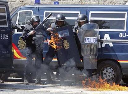 Varios policías se protegen durante la protesta de los trabajadores del metal ayer en Vigo.