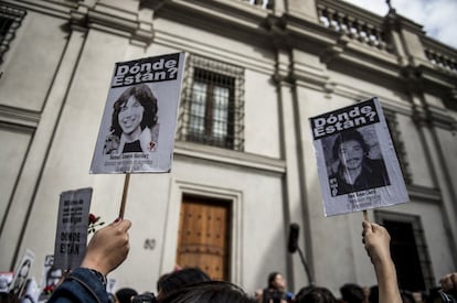 Ativistas da organização chilena de direitos humanos ‘Pessoas detidas e desaparecidas’ mostram fotografias de desaparecidos em frente ao palácio presidencial de La Moneda, em Santiago.