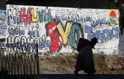 Una boliviana pasea frente a una pintada en apoyo a Morales.