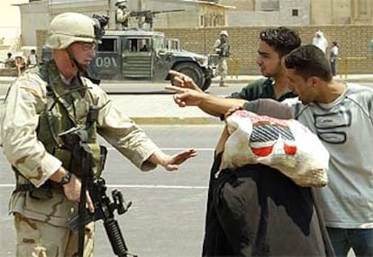 Dos iraquíes discuten con un soldado tras un ataque contra militares estadounidenses ayer en Bagdad.