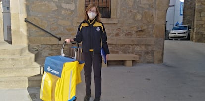 La cartera rural Mariví Torres junto con su carrito de Correos durante un día de reparto en el pueblo El Torno.