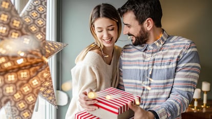 Una pareja en Navidad con dos regalos en la mano.