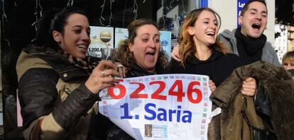 Agraciados con el Gordo posan en la puerta de la administación que ha vendido los décimos premiados en Mondragón.