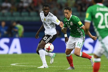 El defensa de la selección de Alemania Antonio Ruediger (izquierda) compite por el balón con Javier Hernández.