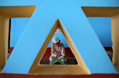 Un niño musulmán lee el Corán dentro de una mezquita el primer día del santo mes de ayuno de Ramadán, en las afueras de Agartala (India), el 7 de mayo de 2019.