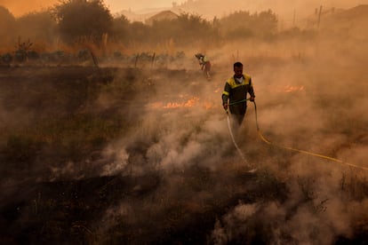 Los bomberos intentan apagar el fuego durante el incendio forestal en Santa Baia De Montes, este jueves.