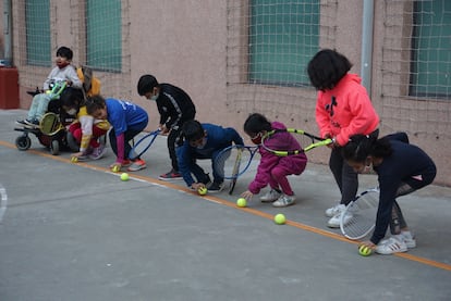 Un grupo de niños juegan con raquetas y pelotas en el Centro Socioeducativo Poble-sec (Barcelona) de la Fundación Pere Tarrés, que ofrece clases gratuitas de tenis a niños que habitualmente no tienen acceso a este deporte.