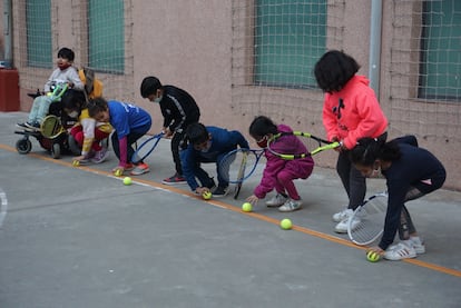 Un grupo de niños juegan con raquetas y pelotas en el Centro Socioeducativo Poble-sec (Barcelona) de la Fundación Pere Tarrés, que ofrece clases gratuitas de tenis a niños que habitualmente no tienen acceso a este deporte. 