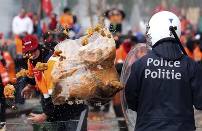 La Policía local de Bruselas indicó a Efe que su cálculo oficial del número de asistentes a la marcha está en torno a 25.500 personas, aunque la Confederación Europea de Sindicatos (CES) aseguró que hay unas 40.000 personas, una cifra que ha calificado la concurrencia de "éxito". En la imagen, un manifestante lanza una bolsa de basura a la policía, 4 de abril de 2014.