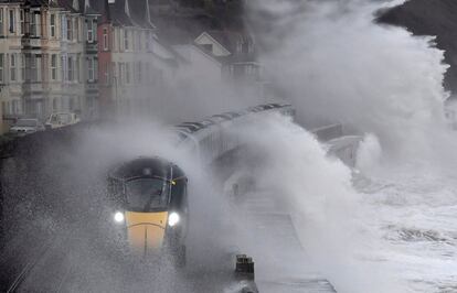 Grandes olas rompen sobre un tren cuando pasa por Dawlish, en el suroeste de Gran Bretaña.