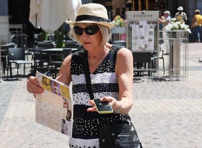 Una turista sujeta en una mano un plano de Madrid y en la otra un móvil, en centro de la capital.