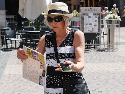 Una turista sujeta en una mano un plano de Madrid y en la otra un móvil, en centro de la capital.